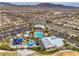 Community aerial view showcasing a pool, splash pad, picnic pavilion, and well-maintained landscaping amidst homes and desert landscape at 9655 Shadow Cliff Ave, Las Vegas, NV 89166