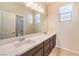 Bright bathroom featuring a dual sink vanity, tile floors, and a large mirror at 9655 Shadow Cliff Ave, Las Vegas, NV 89166