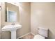 Clean half-bathroom featuring a pedestal sink, toilet, and tiled floors at 9655 Shadow Cliff Ave, Las Vegas, NV 89166