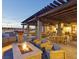 An outdoor space offers dining tables and wood seating with a built in fire pit for community enjoyment at 9655 Shadow Cliff Ave, Las Vegas, NV 89166