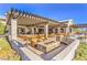 Beautifully designed outdoor patio with a fire pit, ample seating, and a pergola, perfect for entertaining guests at 9655 Shadow Cliff Ave, Las Vegas, NV 89166