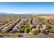 An aerial view showcases a well-planned community with uniform houses and landscaped streets, set against a mountain backdrop at 9986 Sand Key St, Las Vegas, NV 89178