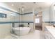 Bright bathroom showcasing a soaking tub, glass-enclosed shower, and modern fixtures at 9986 Sand Key St, Las Vegas, NV 89178