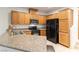 Well-equipped kitchen featuring wood cabinets, granite countertops, and modern black appliances at 9986 Sand Key St, Las Vegas, NV 89178