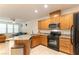 Bright kitchen with granite countertops and black appliances, seamlessly blending into the living room at 9986 Sand Key St, Las Vegas, NV 89178