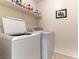 Convenient laundry room with washer, dryer, and shelving for storage at 9986 Sand Key St, Las Vegas, NV 89178