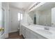 Bright bathroom with double vanity, large mirror, and tiled shower at 10075 Yellow Canary Ave, Las Vegas, NV 89117