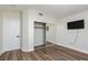 Bedroom features vaulted ceiling, wood-look floors, and mirrored closet at 10075 Yellow Canary Ave, Las Vegas, NV 89117