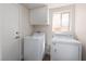 Functional laundry room with included washer, dryer, and built-in overhead cabinets at 10075 Yellow Canary Ave, Las Vegas, NV 89117