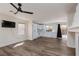 Spacious living room features wood flooring, large windows and a view of the kitchen with white cabinetry at 10075 Yellow Canary Ave, Las Vegas, NV 89117