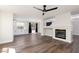 Open floor plan features wood flooring, fireplace, and view of the kitchen with white cabinetry at 10075 Yellow Canary Ave, Las Vegas, NV 89117
