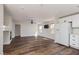 Open-concept living room features wood flooring, and a view of the kitchen with white cabinetry at 10075 Yellow Canary Ave, Las Vegas, NV 89117
