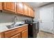 Functional laundry room with cabinetry, sink, and modern washer/dryer appliances at 10259 Wolves Den Ln, Las Vegas, NV 89178