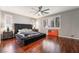 The main bedroom boasts hardwood floors, plantation shutters and a large bed at 10259 Wolves Den Ln, Las Vegas, NV 89178