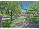 Landscaped front yard with mature trees leading to a charming home with multiple garage spaces at 1121 Via Castelli, Henderson, NV 89052