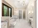 Bright primary bath with marble countertops, a soaking tub, and a separate vanity area at 1200 Dry Point Ct, Las Vegas, NV 89144