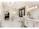 Bright primary bath with marble countertops, a soaking tub, and white cabinetry at 1200 Dry Point Ct, Las Vegas, NV 89144