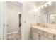 Bright bathroom featuring a marble countertop vanity and neutral finishes with access to the bedroom at 1200 Dry Point Ct, Las Vegas, NV 89144