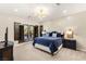 Bedroom with a large window, plush blue bedding, stylish lamps, and sleek ceiling fan at 1200 Dry Point Ct, Las Vegas, NV 89144