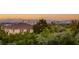 City skyline behind a brown roofed house surrounded by lush greenery at 1200 Dry Point Ct, Las Vegas, NV 89144
