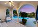 Covered outdoor seating area overlooking a beautiful pool and manicured landscaping at 1200 Dry Point Ct, Las Vegas, NV 89144