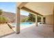Spacious covered back patio that looks out onto the refreshing pool and meticulously landscaped backyard at 17 Morninglow Pass, Henderson, NV 89052
