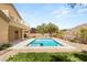Backyard with a rectangular pool, desert landscaping, and second story home in the background at 17 Morninglow Pass, Henderson, NV 89052