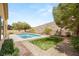 Backyard with a pool, desert landscaping, green grass and hill views at 17 Morninglow Pass, Henderson, NV 89052