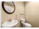 Powder room featuring a pedestal sink, toilet, and a decorative mirror at 17 Morninglow Pass, Henderson, NV 89052