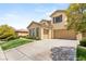 Inviting home showcasing a manicured lawn, mature trees, and a spacious driveway leading to a two-car garage at 17 Morninglow Pass, Henderson, NV 89052