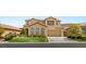 Charming two-story stucco home with a well-manicured front lawn, mature landscaping, and a two-car garage at 17 Morninglow Pass, Henderson, NV 89052