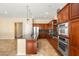 Open-concept kitchen featuring stainless steel appliances, wood cabinets, and marble floors at 17 Morninglow Pass, Henderson, NV 89052
