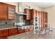 Modern kitchen featuring stainless steel appliances, granite countertops, and wood cabinets at 17 Morninglow Pass, Henderson, NV 89052