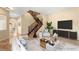 Elegant living room featuring a staircase, neutral colors, and comfortable seating arrangements at 17 Morninglow Pass, Henderson, NV 89052