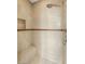 Walk in shower featuring tile surround, shower head, and built-in shelf at 17 Morninglow Pass, Henderson, NV 89052