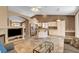 Open-concept living room with fireplace, tile flooring, and spacious kitchen at 1931 Jasper Creek Pl, Las Vegas, NV 89123