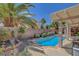 Relaxing backyard oasis with a refreshing pool, mature palms, and covered patio for outdoor enjoyment at 1931 Jasper Creek Pl, Las Vegas, NV 89123