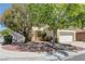 Inviting single-story home with desert landscaping, a two-car garage, and mature shade trees enhancing curb appeal at 1945 Trail Peak Ln, Las Vegas, NV 89134