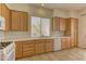 Functional kitchen with tile countertops, wood cabinetry, and white appliances for a clean, efficient cooking space at 1945 Trail Peak Ln, Las Vegas, NV 89134