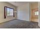 Bright living area with neutral carpet, a decorative light fixture, and large windows for natural light at 1945 Trail Peak Ln, Las Vegas, NV 89134