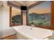 Serene bathroom featuring a freestanding tub, and large windows framing stunning mountain views, creating a spa-like atmosphere at 2369 Green Mountain Ct, Las Vegas, NV 89135