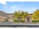 Desert home with lush landscaping, three car garage, and inviting entrance creating a welcoming curb appeal at 2369 Green Mountain Ct, Las Vegas, NV 89135