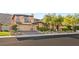A desert home featuring a three-car garage, lush landscaping, and beautiful stone accents for enhanced curb appeal at 2369 Green Mountain Ct, Las Vegas, NV 89135