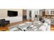 Comfortable living room with plush seating, mounted television, and view of staircase to upper level at 2369 Green Mountain Ct, Las Vegas, NV 89135