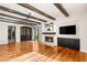 Bright living room with hardwood floors, exposed beam ceiling, fireplace, and built-in cabinets, creating a cozy, stylish space at 2369 Green Mountain Ct, Las Vegas, NV 89135