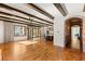 Living room with hardwood floors, exposed beam ceiling, large window, glass doors, and seamless transition to the adjacent kitchen area at 2369 Green Mountain Ct, Las Vegas, NV 89135