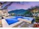 Mountain view of backyard featuring pool with tile trim and desert landscaping with vibrant pink flowers at 2369 Green Mountain Ct, Las Vegas, NV 89135
