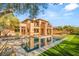 Stunning backyard featuring a modern pool, spa, and beautifully landscaped yard with lush greenery reflecting on the water's surface at 2369 Green Mountain Ct, Las Vegas, NV 89135