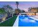 A view of the pool with desert landscaping in the background and trees surrounding the area at 2369 Green Mountain Ct, Las Vegas, NV 89135