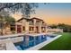 Stunning backyard pool and spa with travertine trim, fire pit, and meticulously landscaped yard at 2369 Green Mountain Ct, Las Vegas, NV 89135